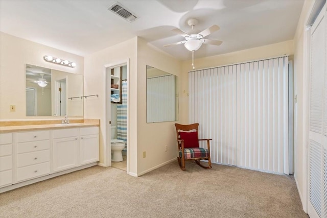 sitting room with sink, light colored carpet, and ceiling fan