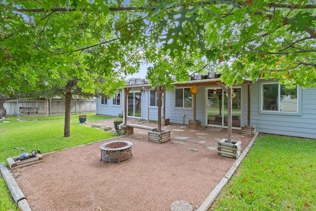 rear view of property featuring a yard and a fire pit