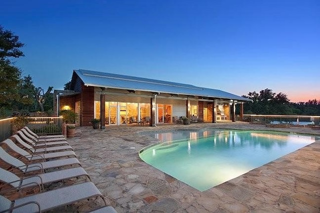 pool at dusk with a patio