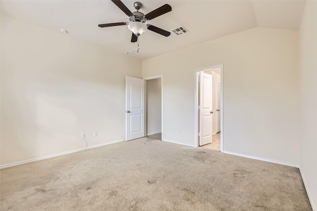 unfurnished bedroom with ceiling fan, light colored carpet, vaulted ceiling, and ensuite bath