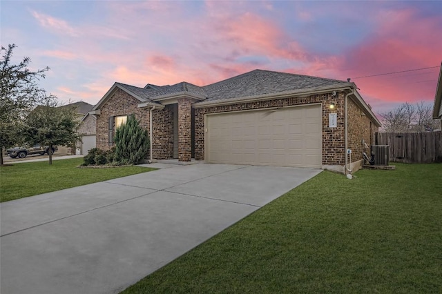 view of front of property featuring a garage, a yard, and cooling unit