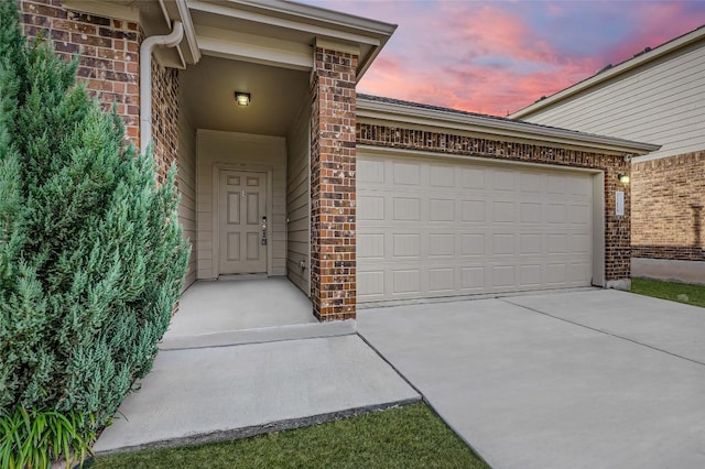 exterior entry at dusk featuring a garage