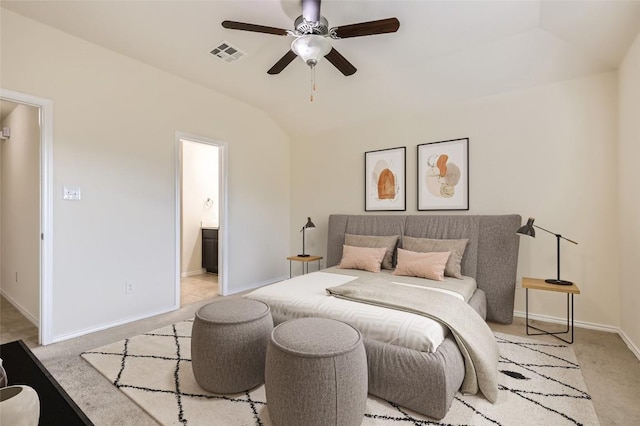 bedroom featuring lofted ceiling, light colored carpet, connected bathroom, and ceiling fan