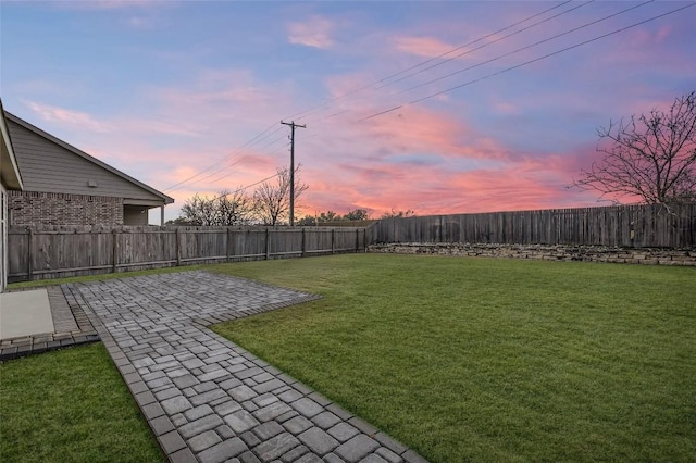 yard at dusk featuring a patio