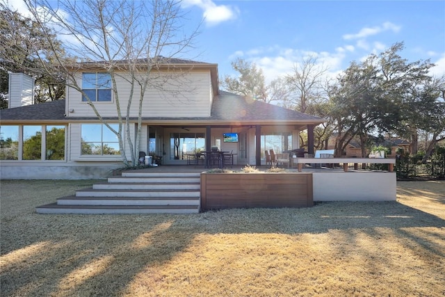 back of house with a patio and a lawn