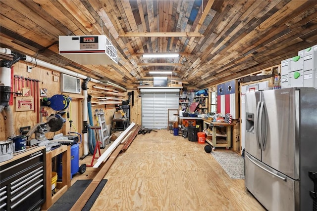 garage with wooden walls, a workshop area, wooden ceiling, and stainless steel refrigerator with ice dispenser