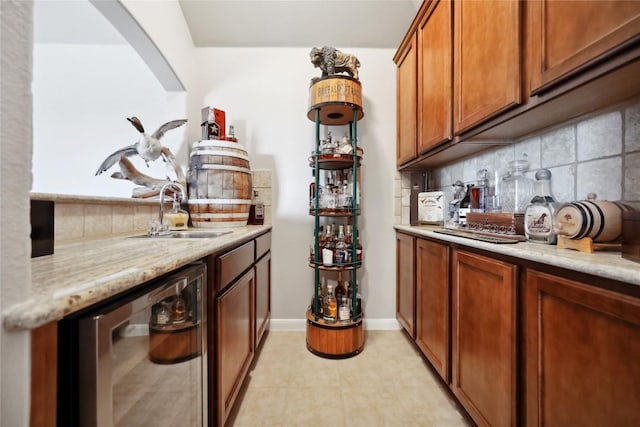 bar featuring light stone countertops, sink, wine cooler, and backsplash