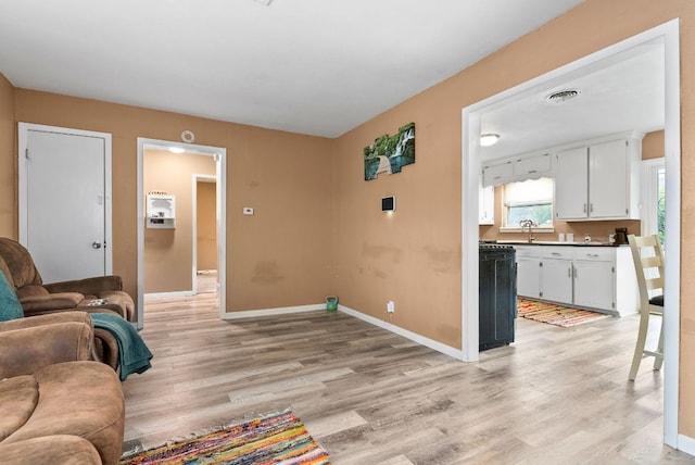 living room featuring sink and light hardwood / wood-style floors