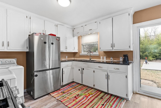 kitchen featuring white cabinetry, stainless steel fridge, sink, and light wood-type flooring