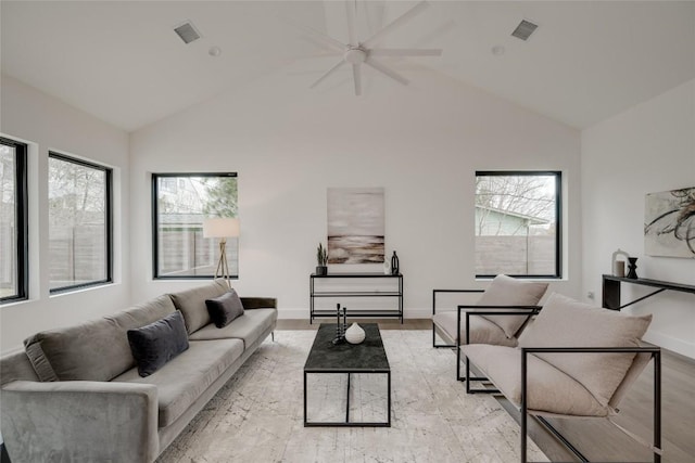 living room with plenty of natural light, light wood-type flooring, and high vaulted ceiling