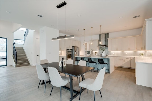 dining space with sink and light wood-type flooring