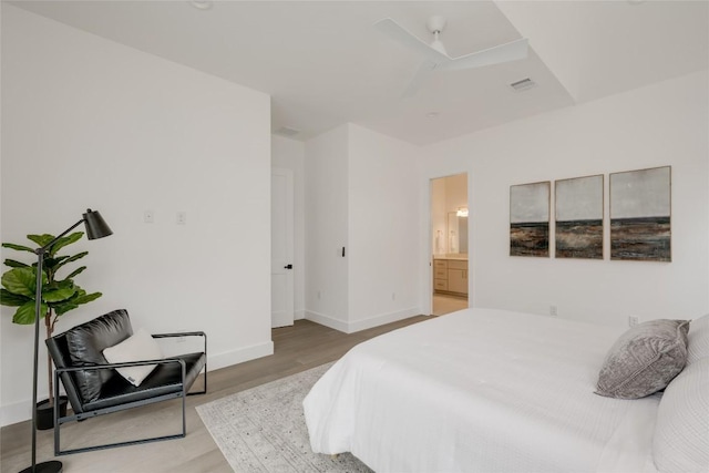 bedroom featuring connected bathroom and hardwood / wood-style floors