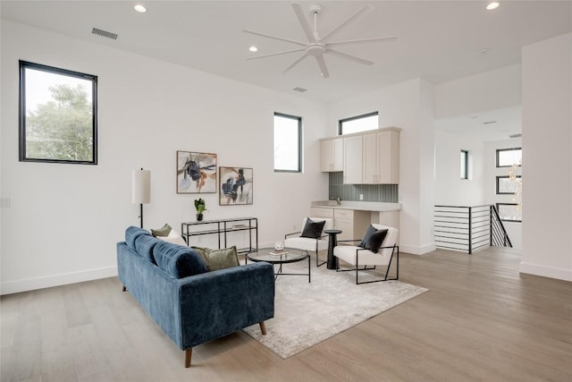 living room with ceiling fan and light hardwood / wood-style floors