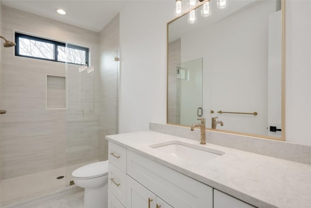 bathroom featuring vanity, an enclosed shower, and toilet