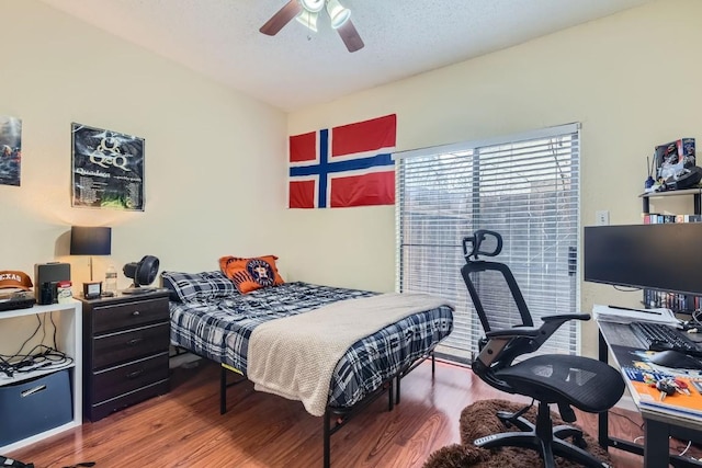 bedroom with ceiling fan, hardwood / wood-style flooring, and a textured ceiling