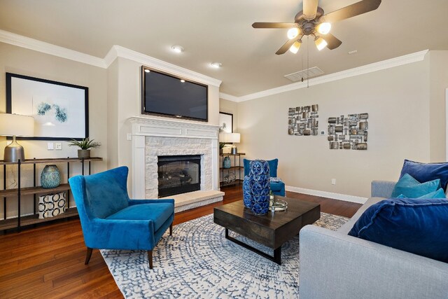 living room with ceiling fan, ornamental molding, a fireplace, and hardwood / wood-style floors