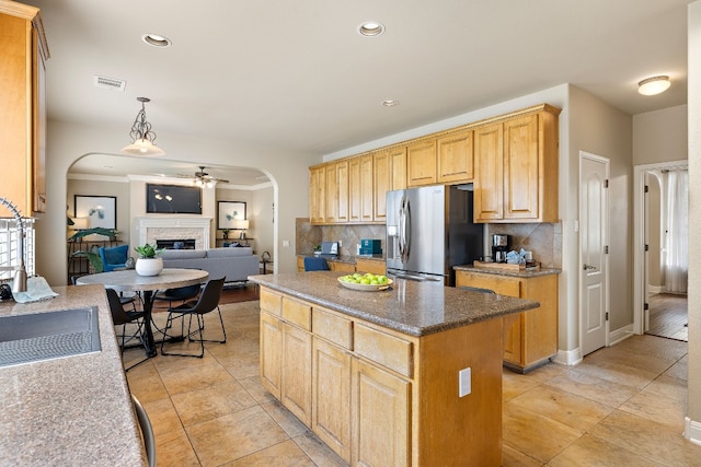 kitchen with ceiling fan, a center island, tasteful backsplash, stainless steel fridge with ice dispenser, and decorative light fixtures