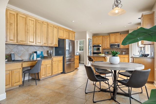 kitchen featuring light stone counters, built in desk, appliances with stainless steel finishes, pendant lighting, and decorative backsplash