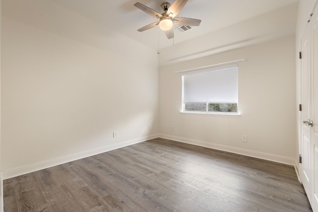 spare room with dark hardwood / wood-style flooring and ceiling fan