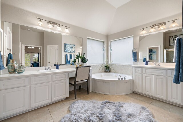 bathroom with lofted ceiling, vanity, tile patterned flooring, and a bathing tub