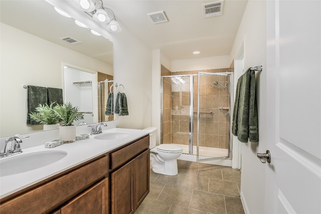 bathroom featuring tile patterned flooring, vanity, an enclosed shower, and toilet