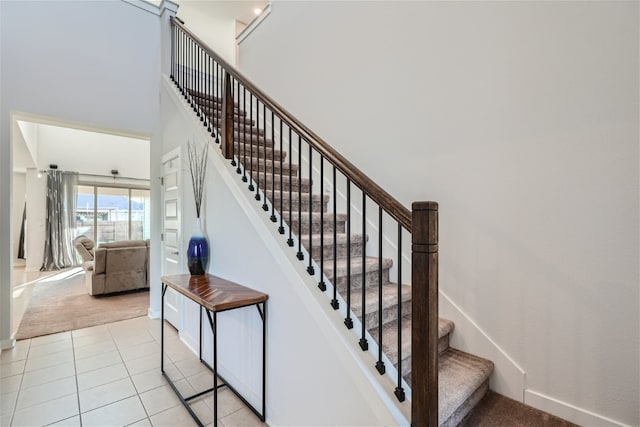 stairs featuring a towering ceiling and carpet