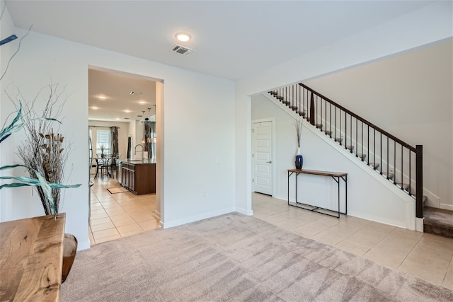 unfurnished living room featuring sink and light colored carpet