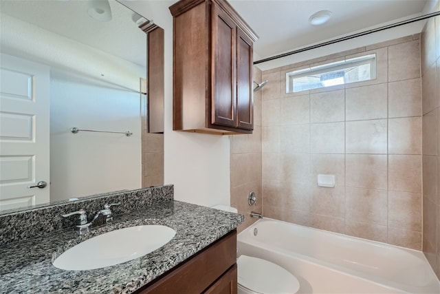 full bathroom with tiled shower / bath combo, vanity, and toilet