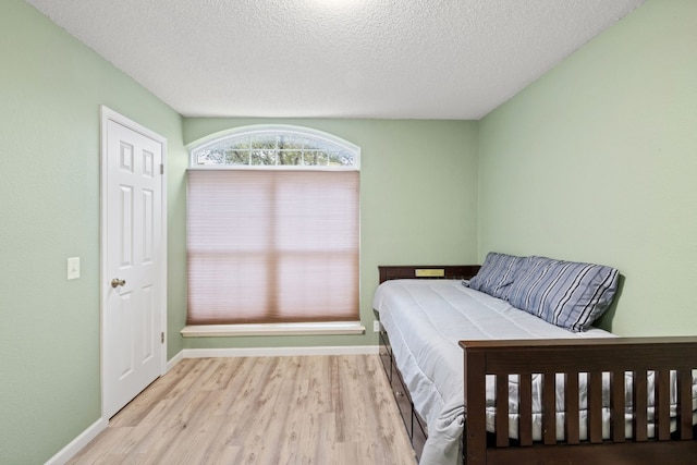 bedroom featuring a textured ceiling and light wood-type flooring