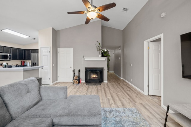 living room with hardwood / wood-style floors, high vaulted ceiling, and ceiling fan