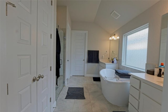 16817 Adoro Dr, Manor, TX 78653 - full bathroom with lofted ceiling, a stall shower, a soaking tub, two vanities, and tile patterned floors