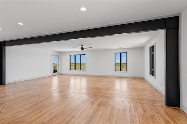 interior space with beam ceiling, light hardwood / wood-style flooring, and ceiling fan