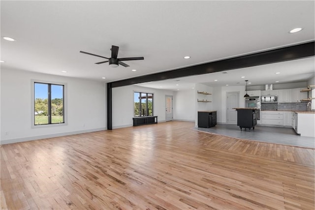 185 Eely Rd, Mcdade, TX 78650 - unfurnished living room with baseboards, light wood-style flooring, ceiling fan, and recessed lighting