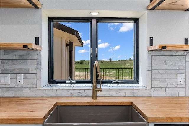 room details featuring tasteful backsplash, butcher block counters, and sink