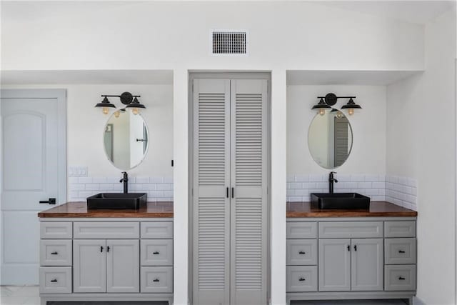 bathroom with vanity and decorative backsplash