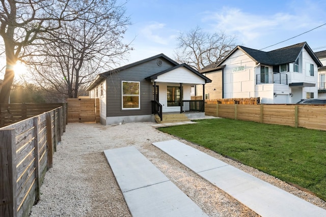 bungalow with covered porch and a front lawn