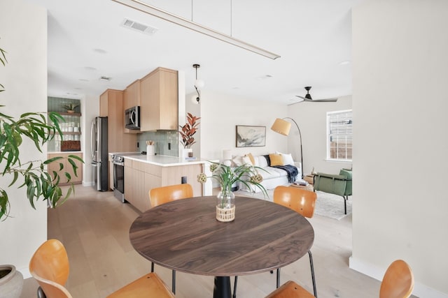 dining space featuring ceiling fan and light hardwood / wood-style floors