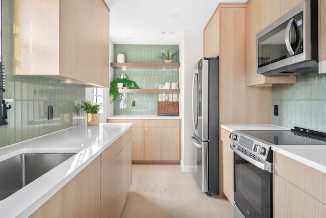 kitchen with stainless steel appliances, light hardwood / wood-style flooring, light brown cabinetry, and decorative backsplash