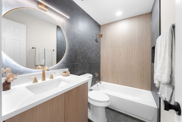 full bathroom featuring tile walls, tile patterned flooring, vanity, tiled shower / bath, and toilet