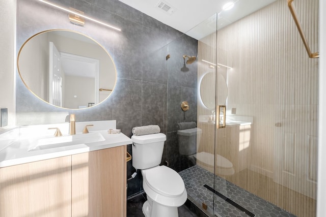 bathroom featuring vanity, tile walls, toilet, and walk in shower