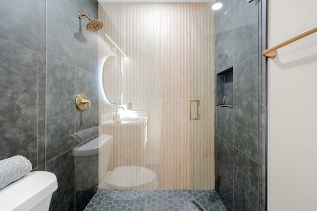 bathroom featuring a shower with shower door and toilet