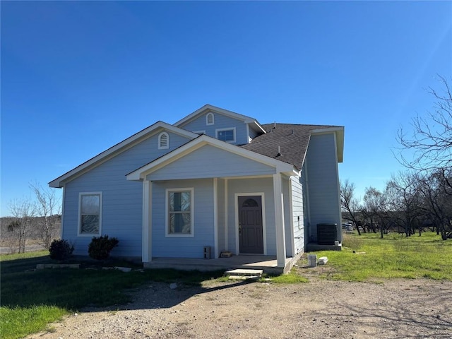 view of front of home with a front lawn, central air condition unit, and covered porch