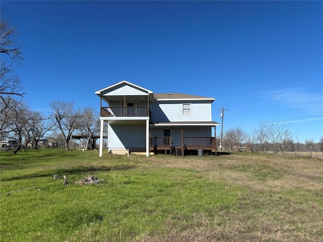 rear view of house featuring a yard and a balcony