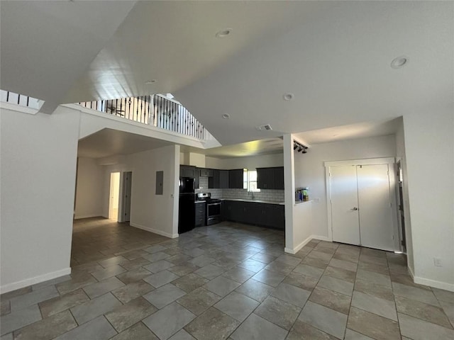 kitchen featuring black refrigerator, tasteful backsplash, stainless steel range oven, and vaulted ceiling