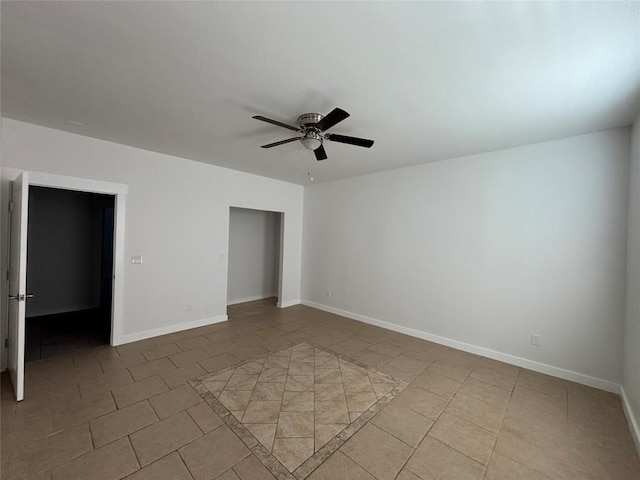 tiled spare room featuring ceiling fan