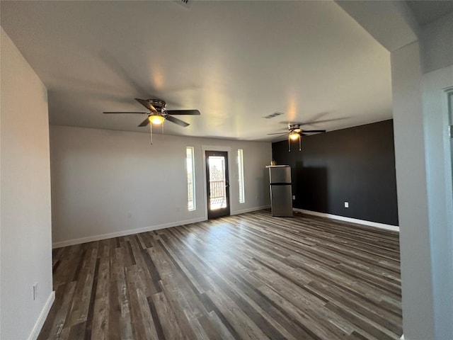 unfurnished living room featuring ceiling fan and dark hardwood / wood-style flooring