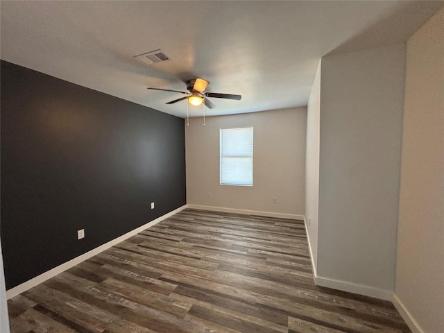 empty room with ceiling fan and dark hardwood / wood-style flooring