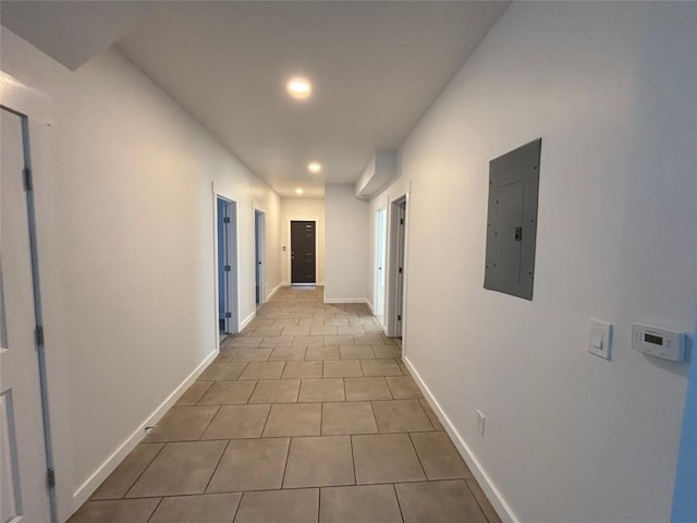 hall featuring electric panel and light tile patterned flooring