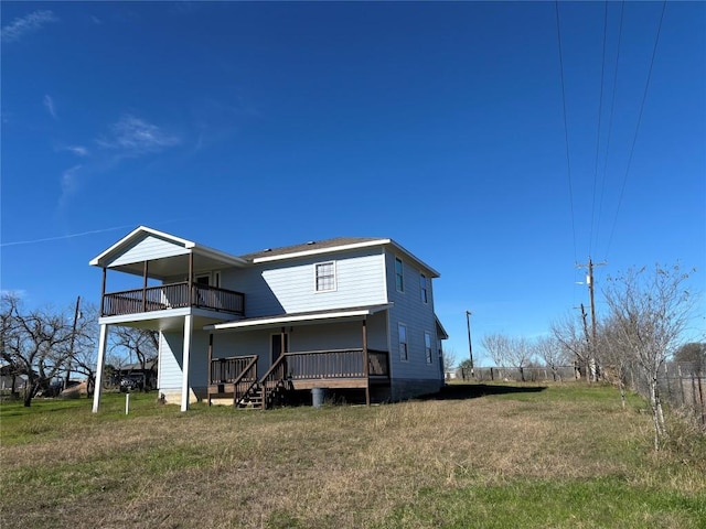 rear view of property with a balcony and a yard