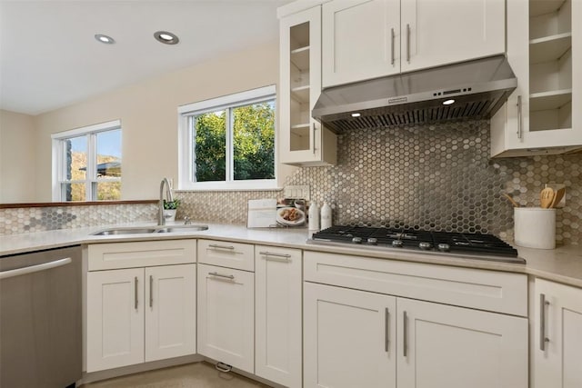 kitchen featuring extractor fan, appliances with stainless steel finishes, tasteful backsplash, white cabinetry, and sink